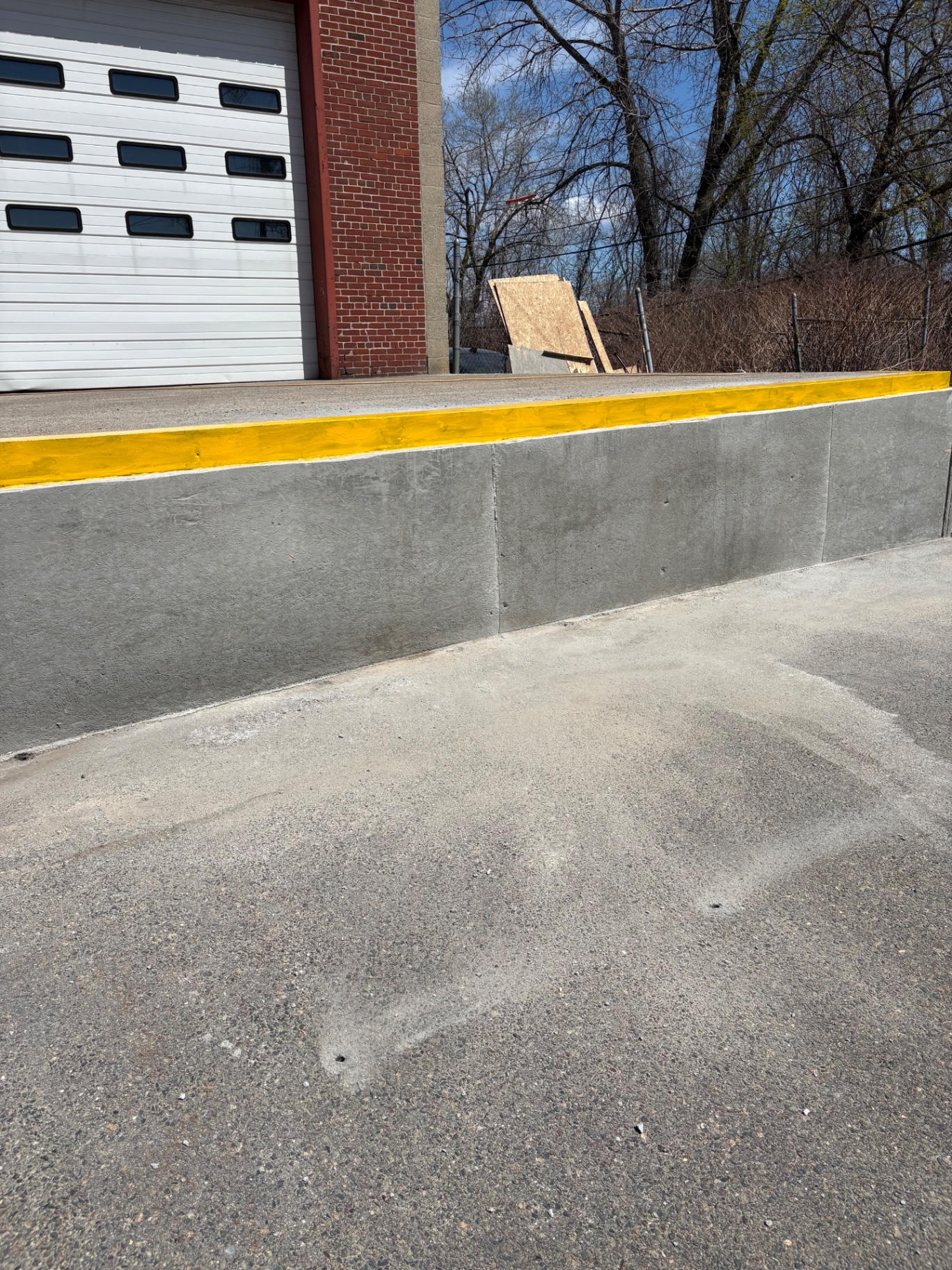 Rebuilt commercial concrete loading dock wall with painted safety edge