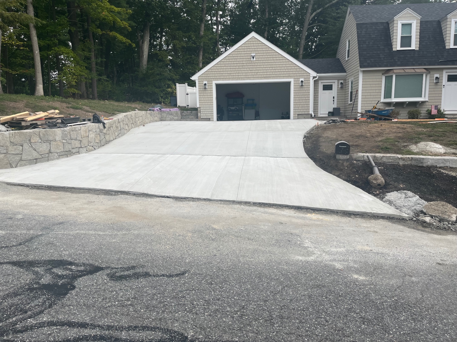Freshly finished concrete driveway in front of a New England home